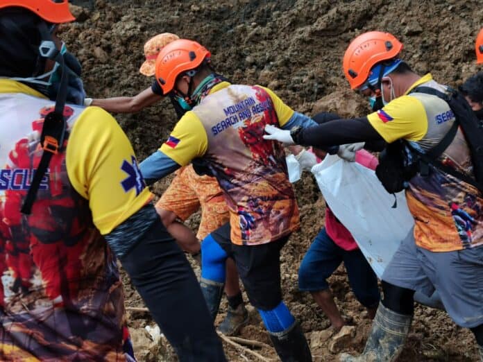 Rescuers from the Esperanza Emergency Rescue Team carry a body retrieved near the river at the landslide site. (Photo courtesy of MDRRMO Esperanza)