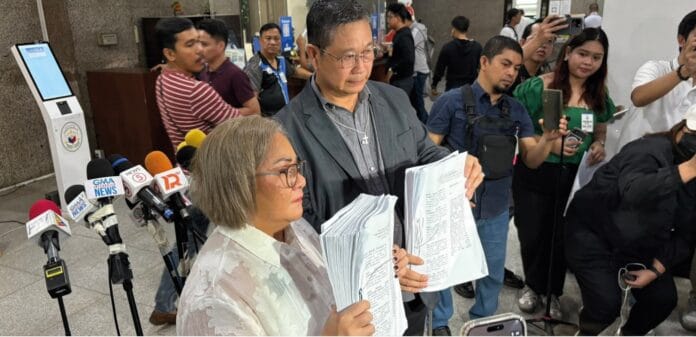 Lawyer Mary Helen Zafra, a staunch critic of Rep. Romeo Momo Sr, and a priest show to Manila reporters the plunder and graft complaint they filed against Momo. Photo courtesy of ABS-CBN News