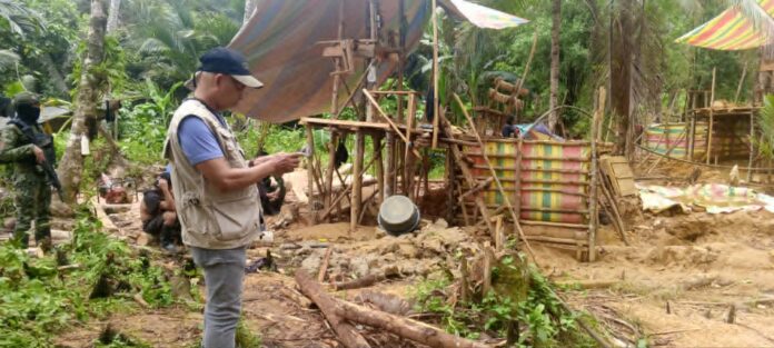 An enforcement team member documents a makeshift mining site in Barobo, Surigao del Sur, after authorities conducted anti-illegal mining operations.