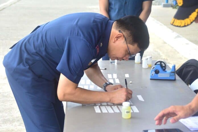 Police Regional Office 13 Director Brig. Gen. Marcial Mariano P. Magistrado IV labels his name in the small urine collection bottle used for the drug test. PRO 13 photo
