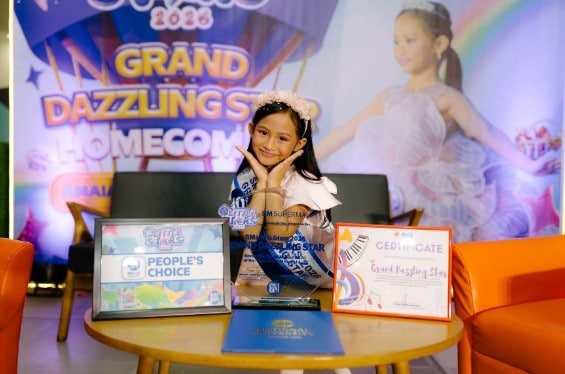 The newly crowned SM Little Stars 2026 Grand Dazzling Star poses with her awards, certificates, and trophies during the Grand Dazzling Star Homecoming celebration.